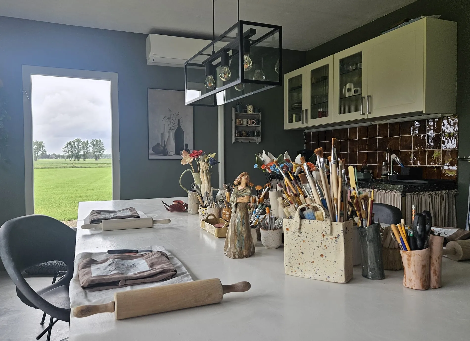 Ons keramiekatelier met werktafel en uitzicht over de weilanden